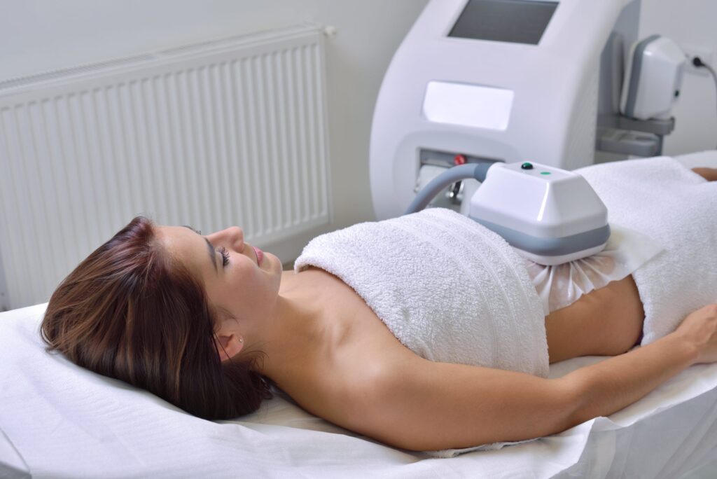 Woman receiving CoolSculpting treatment on abdomen to reduce fat and contour body shape