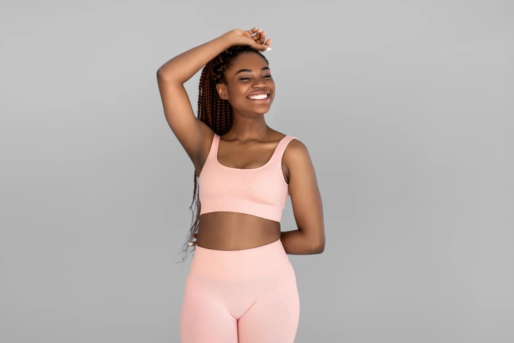 Woman in pink workout attire has great figure after tightening her loose skin.